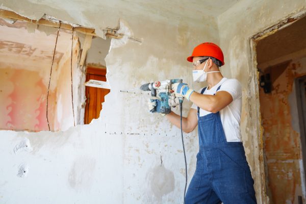 Repairer in boilersuit holding tools. Apartment repair and renovation concept. Building.
